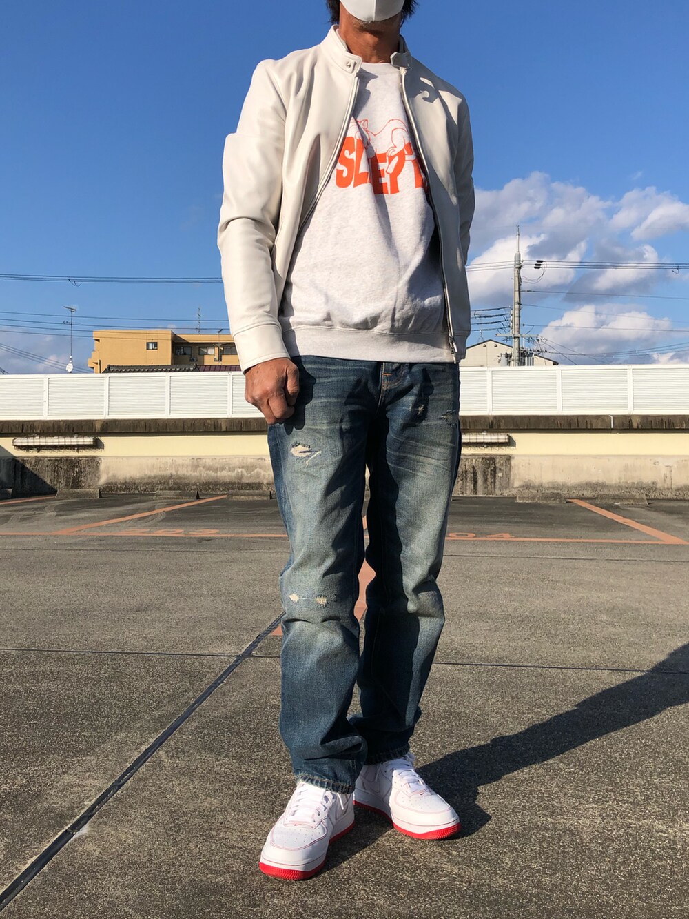 グレー系のスウェット、ホワイト系のブルゾン、ブルー系のデニムパンツを着用したメンズの春コーディネートの3枚目の写真