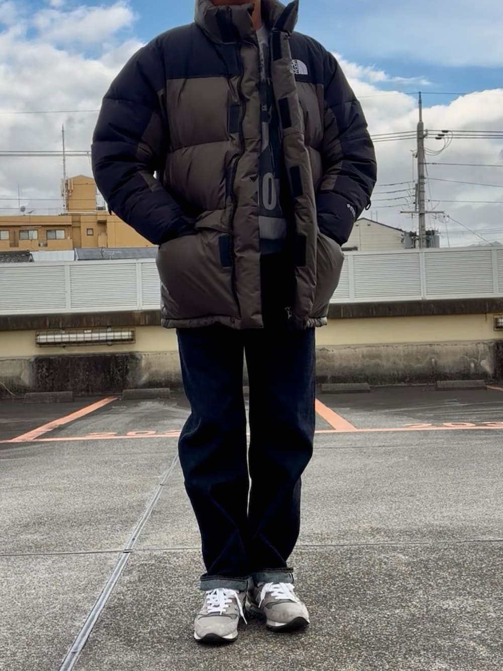 グレー系のスウェット、グリーン系のダウンジャケット/コート、ブルー系のデニムパンツを着用したメンズの冬コーディネートの3枚目の写真