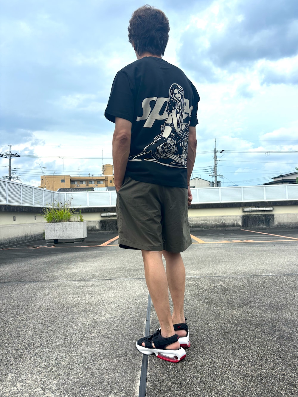 ブラック系のTシャツ/カットソー、グリーン系のその他パンツ、ブラック系のサンダルを着用したメンズの夏コーディネートの2枚目の写真