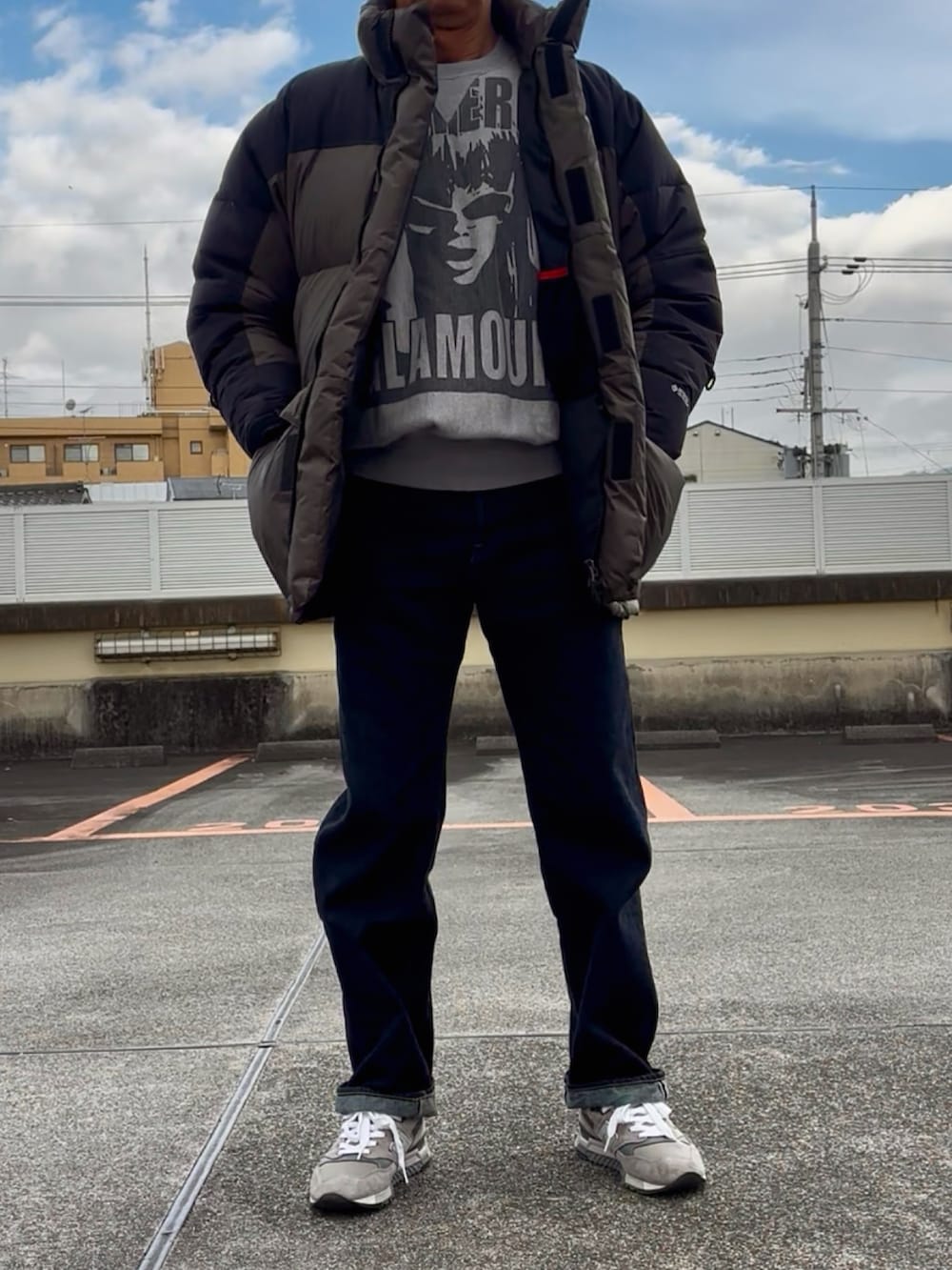 グレー系のスウェット、グリーン系のダウンジャケット/コート、ブルー系のデニムパンツを着用したメンズの冬コーディネートの2枚目の写真