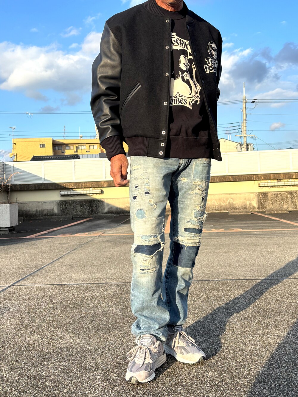 ブラック系のスタジャン、ブラック系のスウェット、ブルー系のデニムパンツを着用したメンズの冬コーディネートの2枚目の写真