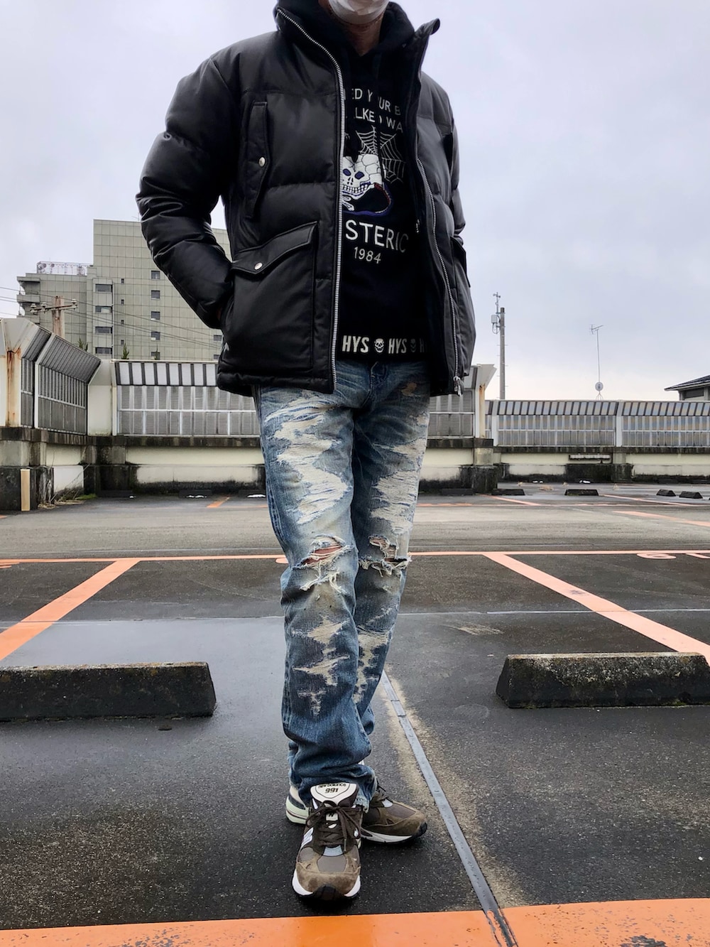 ブラック系のパーカー、ブラック系のダウンジャケット/コート、ブルー系のデニムパンツを着用したメンズの冬コーディネートの2枚目の写真