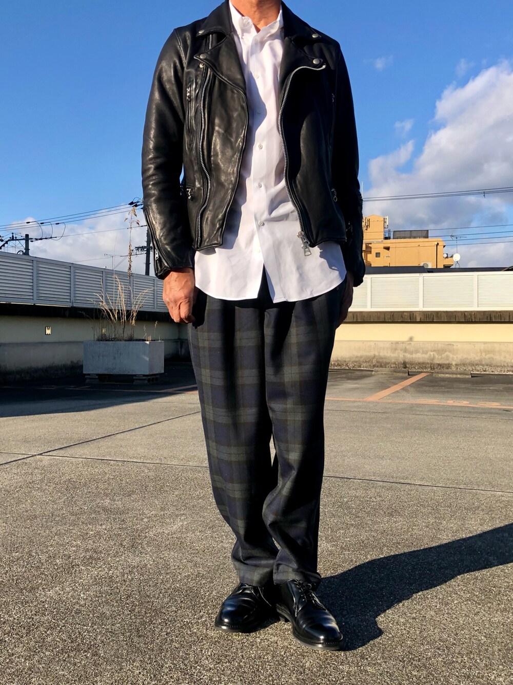 ブラック系のライダースジャケット、ブルー系のその他パンツ、ブラック系のドレスシューズを着用したメンズの冬コーディネートの2枚目の写真