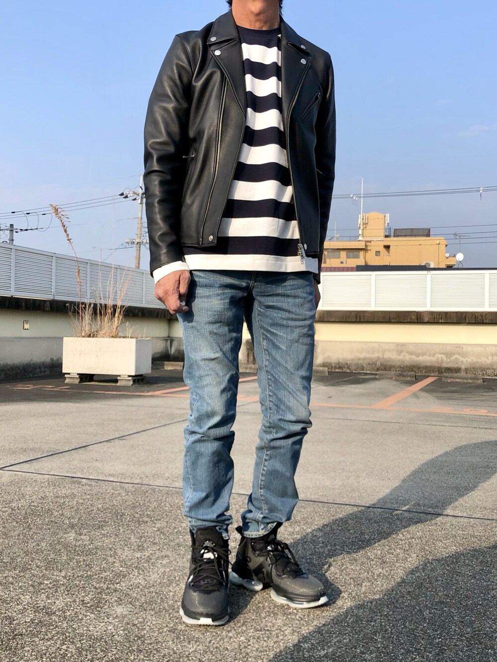 ホワイト系のTシャツ/カットソー、ブラック系のライダースジャケット、ブラック系のスニーカーを着用したメンズの冬コーディネートの2枚目の写真