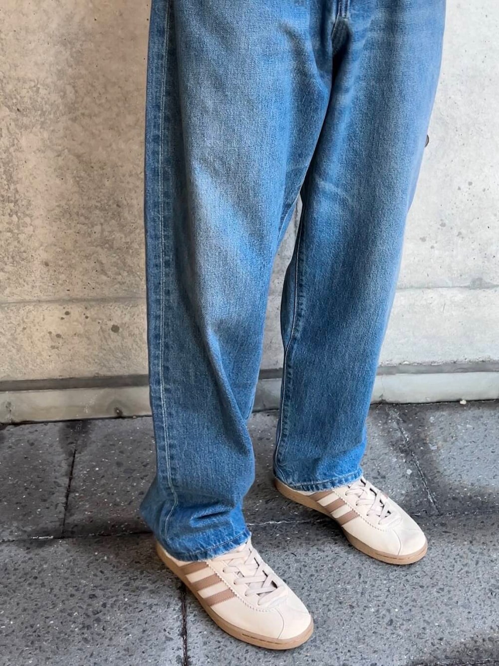 ベージュ系のスニーカー、ブルー系のデニムパンツ、グレー系のパーカーを着用したメンズの秋コーディネートの5枚目の写真