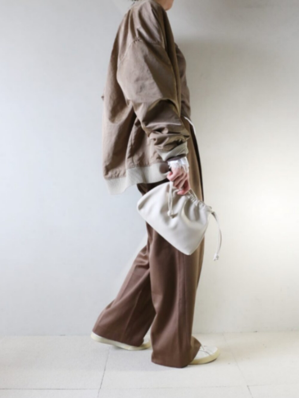 ベージュ系のMA-1、ブラウン系のニット/セーター、ブラウン系のパンツを着用したレディースの秋コーディネートの2枚目の写真