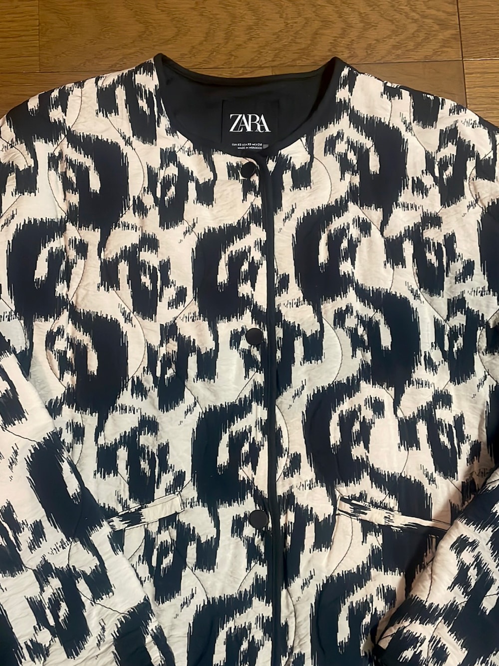 ブラック系のノーカラージャケット、ブラック系のバッグ、ブラック系のパンツを着用したレディースの秋コーディネートの2枚目の写真