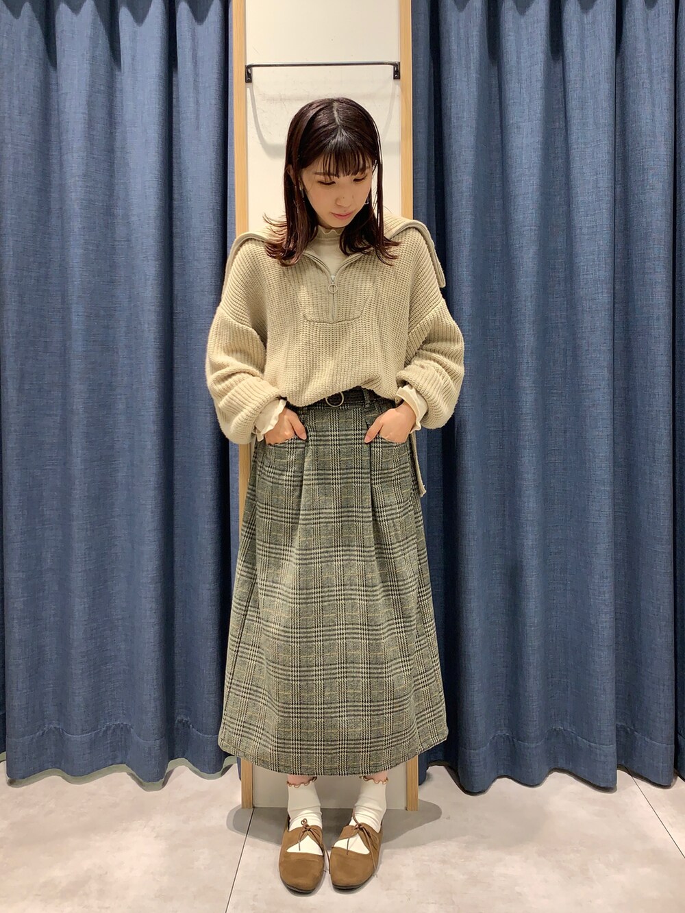 グレー系のスカート、ホワイト系のニット/セーター、ベージュ系のニット/セーターを着用したレディースの秋コーディネートの3枚目の写真