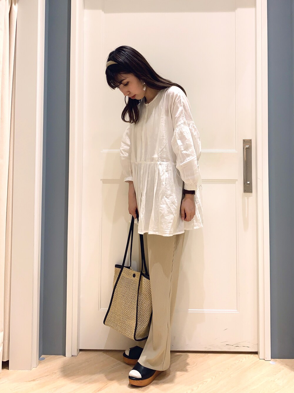 ホワイト系のシャツ/ブラウス、ベージュ系のその他パンツ、ブラック系のハンドバッグを着用したレディースの夏コーディネートの3枚目の写真