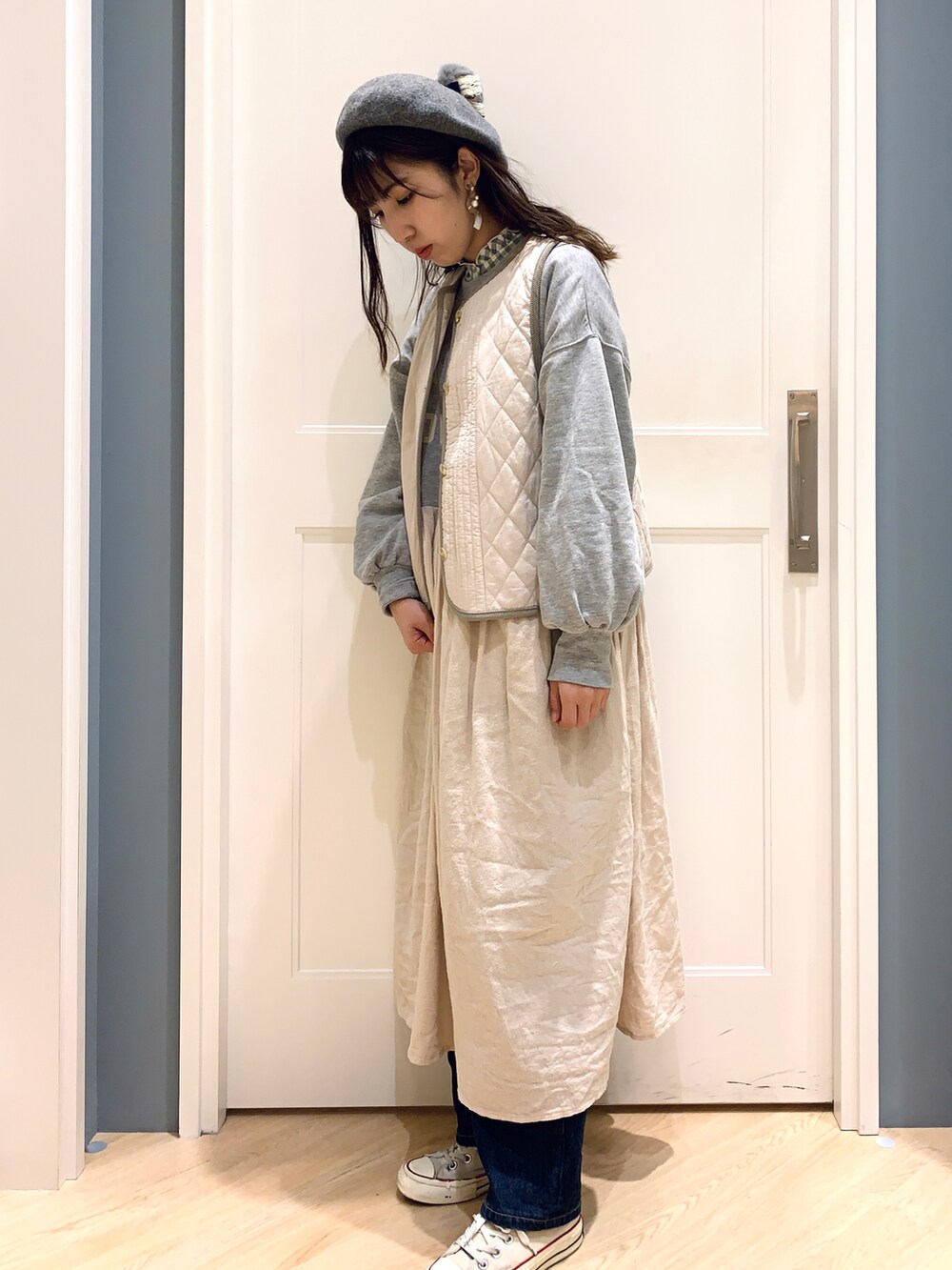 グレー系のワンピース、ホワイト系のベスト、グリーン系のシャツ/ブラウスを着用したレディースの冬コーディネートの3枚目の写真