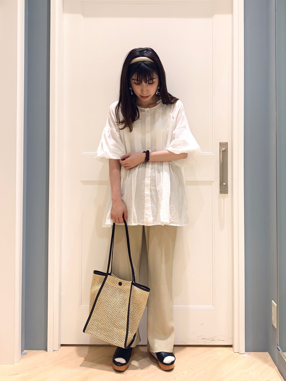 ホワイト系のシャツ/ブラウス、ベージュ系のその他パンツ、ブラック系のハンドバッグを着用したレディースの夏コーディネートの2枚目の写真