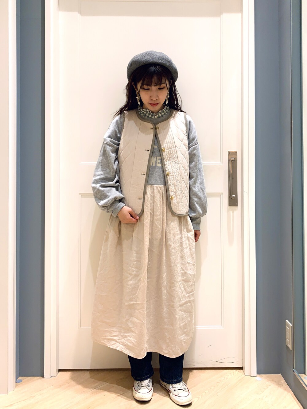 グレー系のワンピース、ホワイト系のベスト、グリーン系のシャツ/ブラウスを着用したレディースの冬コーディネートの2枚目の写真