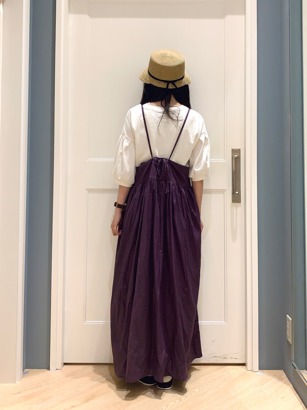 パープル系のワンピース、ホワイト系のTシャツ/カットソー、ベージュ系のハットを着用したレディースの夏コーディネートの3枚目の写真