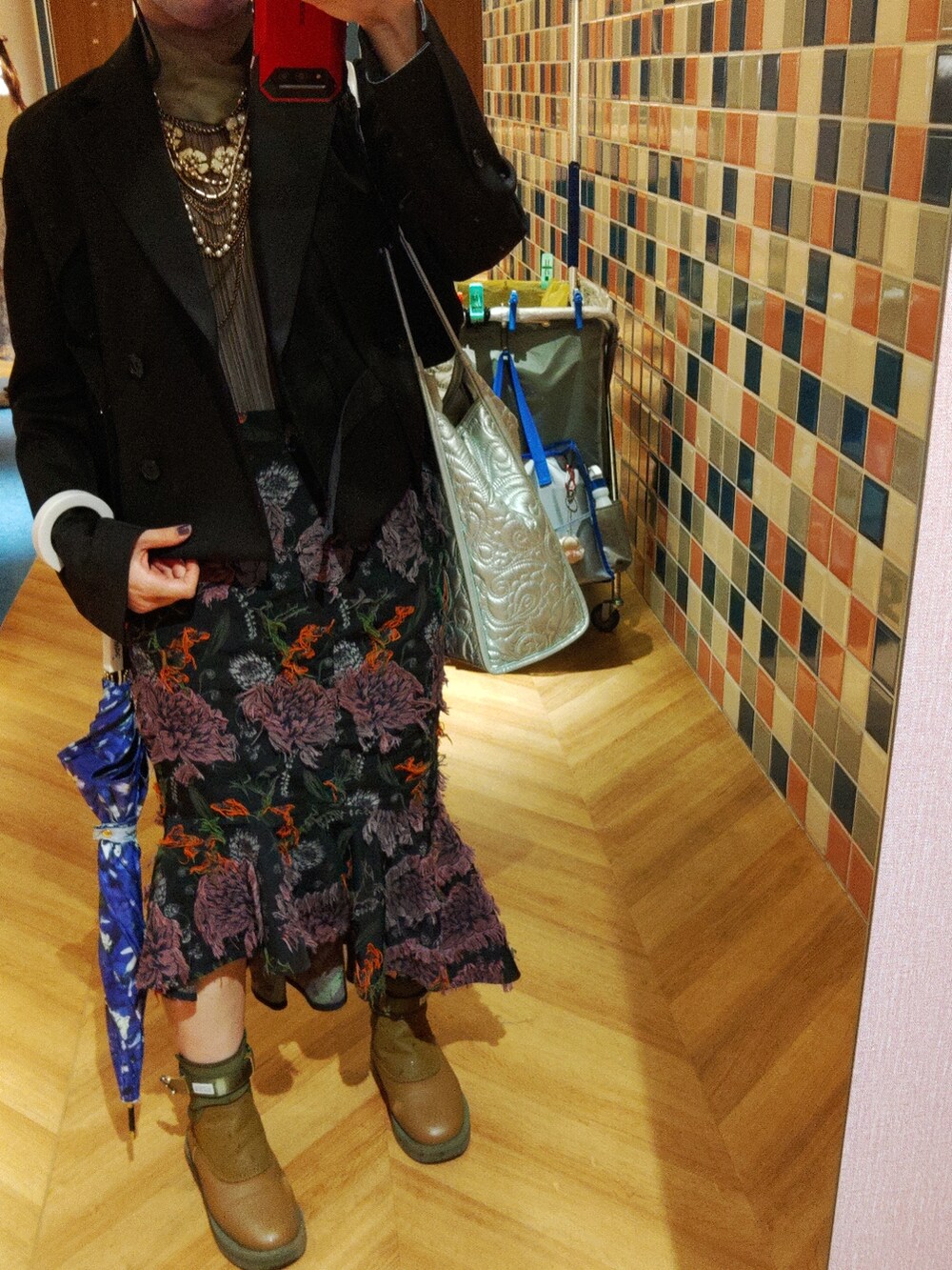 ブラック系のブーツ、シルバー系のトートバッグ、ブラック系のテーラードジャケットを着用したレディースの春コーディネートの4枚目の写真