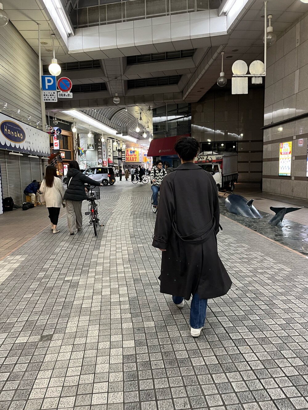 ブラウン系のニット/セーター、ブルー系のデニムパンツ、グレー系のトレンチコートを着用したメンズの春コーディネートの2枚目の写真