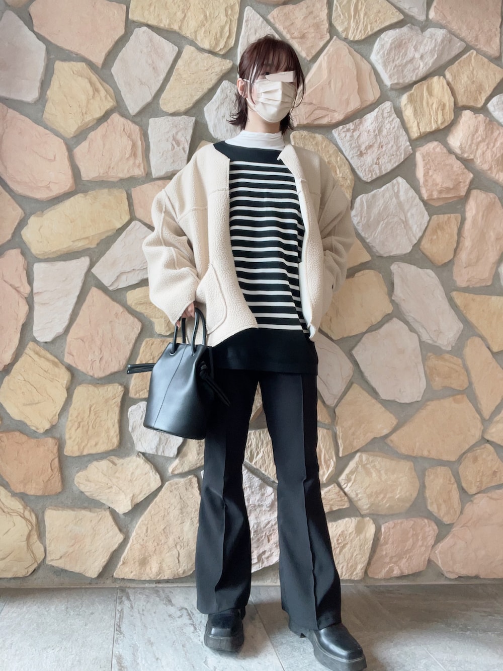 グリーン系のマウンテンパーカー、ベージュ系のマウンテンパーカー、ホワイト系のノーカラーコートを着用したレディースの冬コーディネートの2枚目の写真