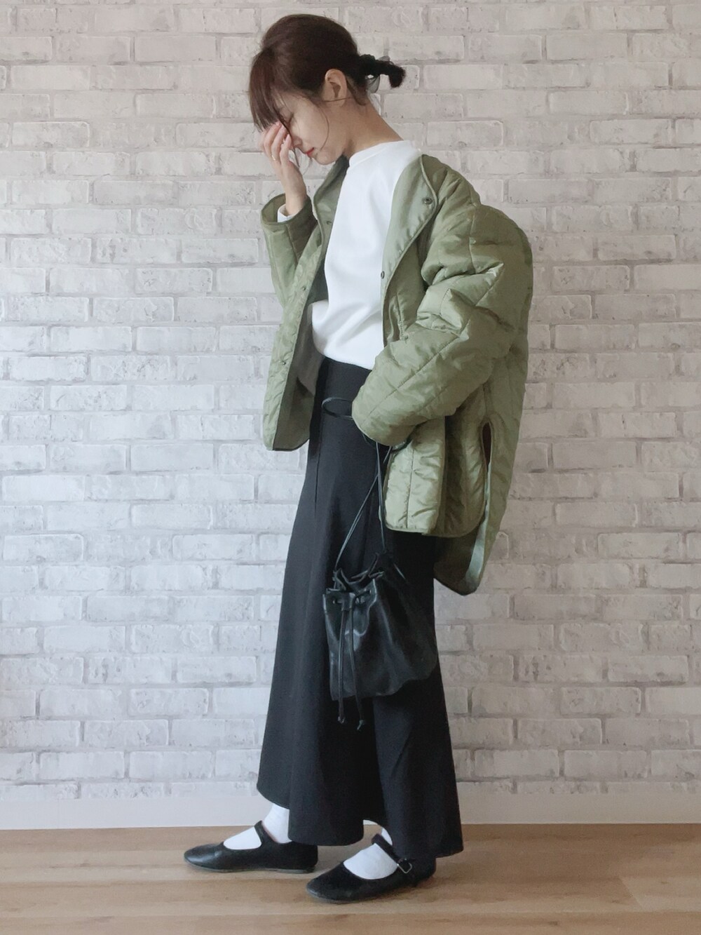 グリーン系のノーカラージャケット、ブラック系のスカート、ブラック系のショルダーバッグを着用したレディースの冬コーディネートの3枚目の写真
