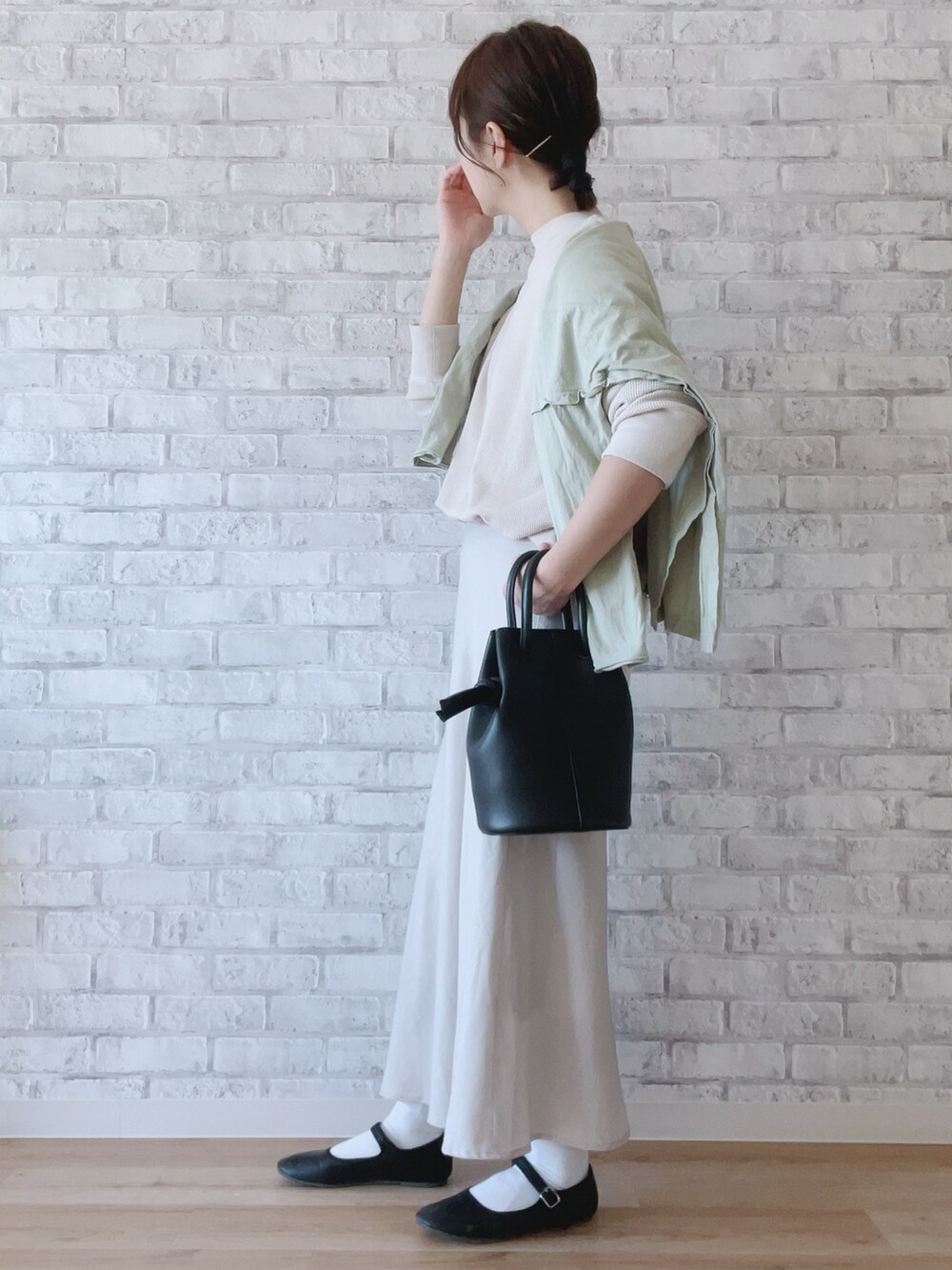 ブラック系のハンドバッグ、ベージュ系のTシャツ/カットソー、ブラック系のバレエシューズを着用したレディースの春コーディネートの2枚目の写真