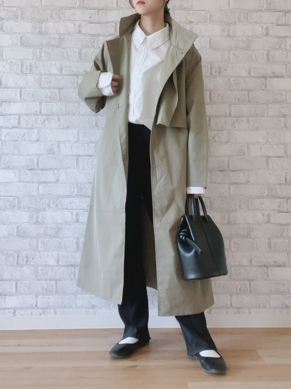 ブラック系のその他パンツ、ホワイト系のシャツ/ブラウス、グリーン系のトレンチコートを着用したレディースの冬コーディネートの2枚目の写真