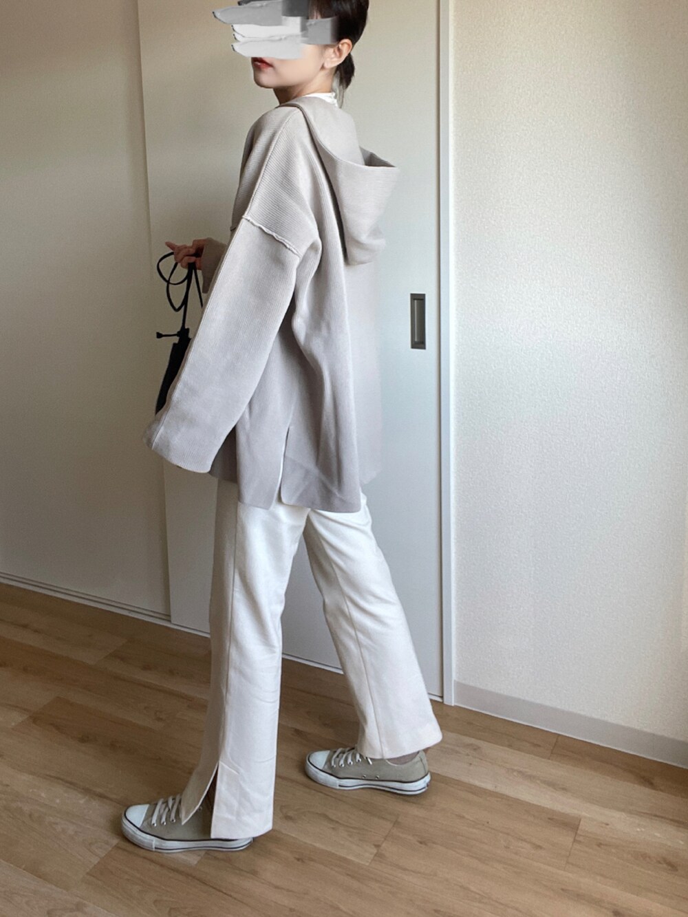 ベージュ系のスニーカー、ブラック系のショルダーバッグ、ベージュ系のニット/セーターを着用したレディースの冬コーディネートの2枚目の写真