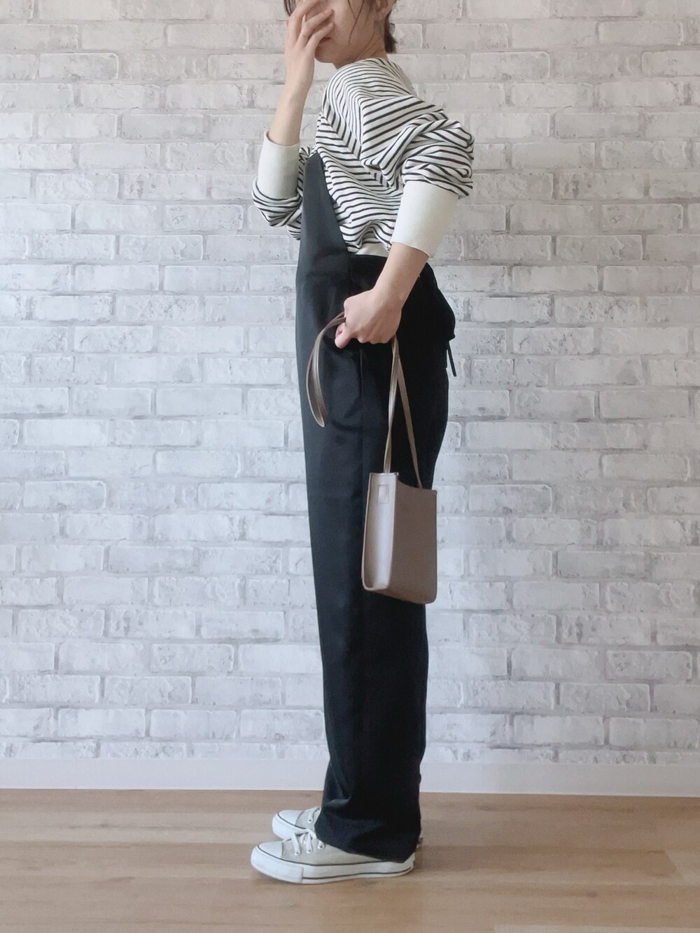 ブラック系のサロペット/オーバーオール、その他のカーディガン/ボレロ、ベージュ系のショルダーバッグを着用したレディースの冬コーディネートの2枚目の写真