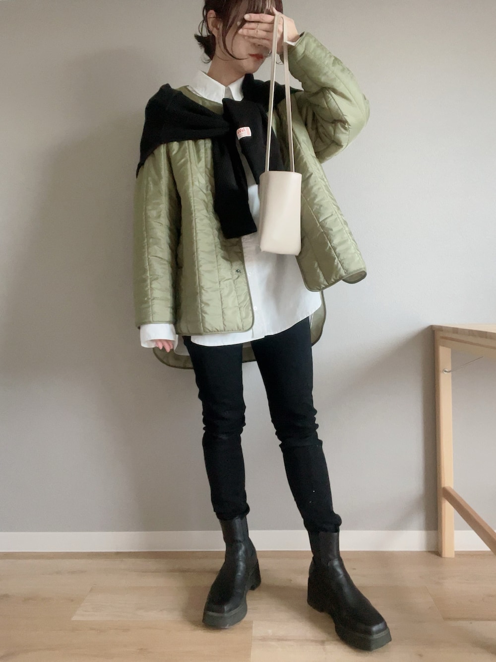 ブラック系のブーツ、ブラック系のデニムパンツ、グリーン系のノーカラージャケットを着用したレディースの冬コーディネートの2枚目の写真