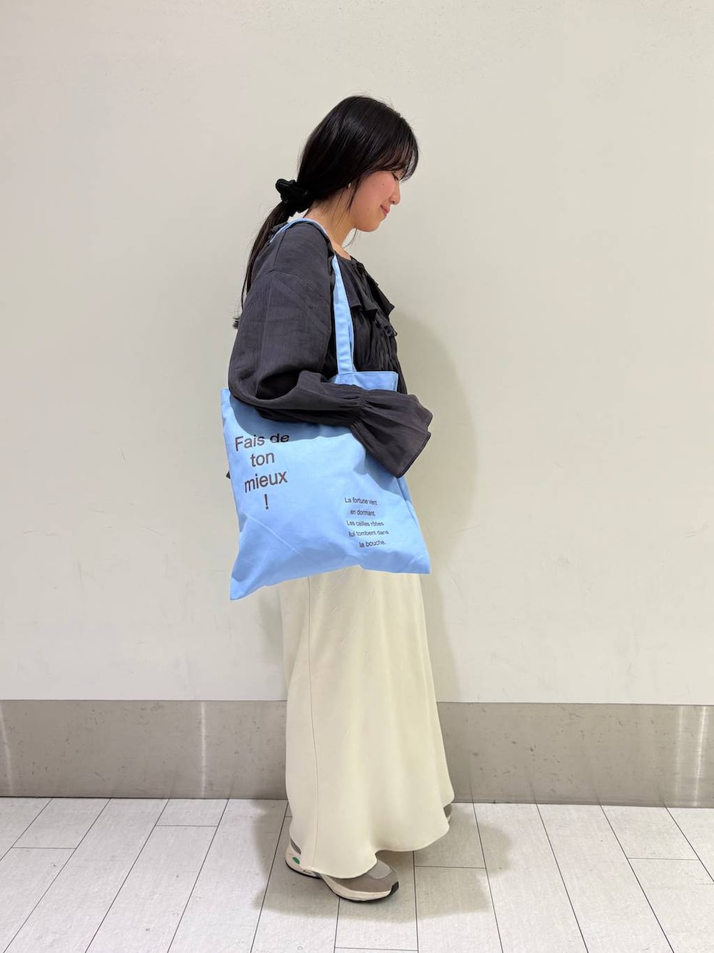 ホワイト系のスカート、ブルー系のトートバッグ、グレー系のシャツ/ブラウスを着用したレディースの春コーディネートの2枚目の写真