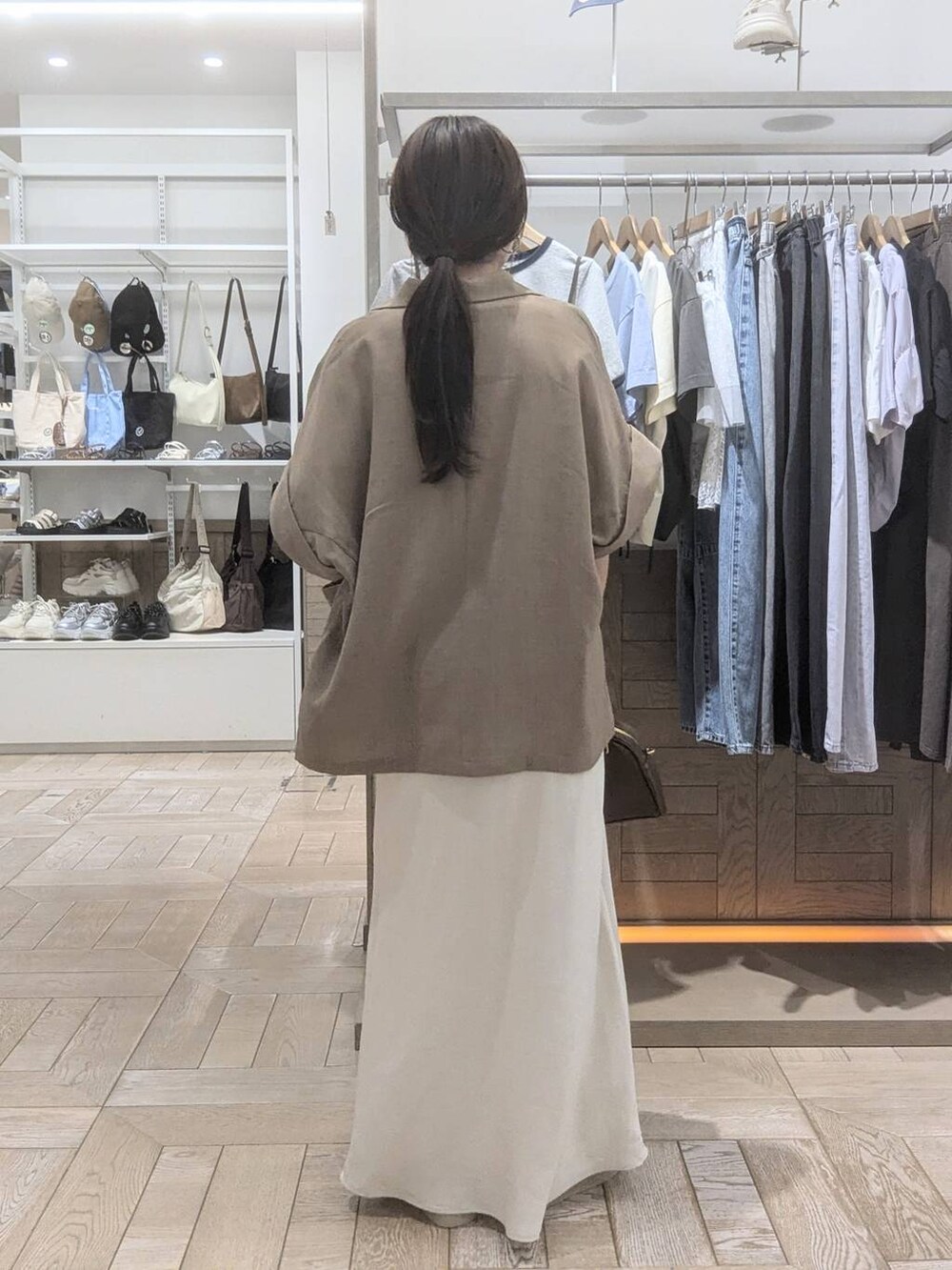 ホワイト系のサンダル、ホワイト系のスカート、ホワイト系のTシャツ/カットソーを着用したレディースの春コーディネートの3枚目の写真