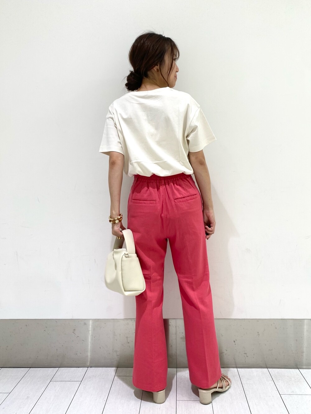 ピンク系のパンツ、ホワイト系のTシャツ/カットソー、ホワイト系のショルダーバッグを着用したレディースの夏コーディネートの2枚目の写真