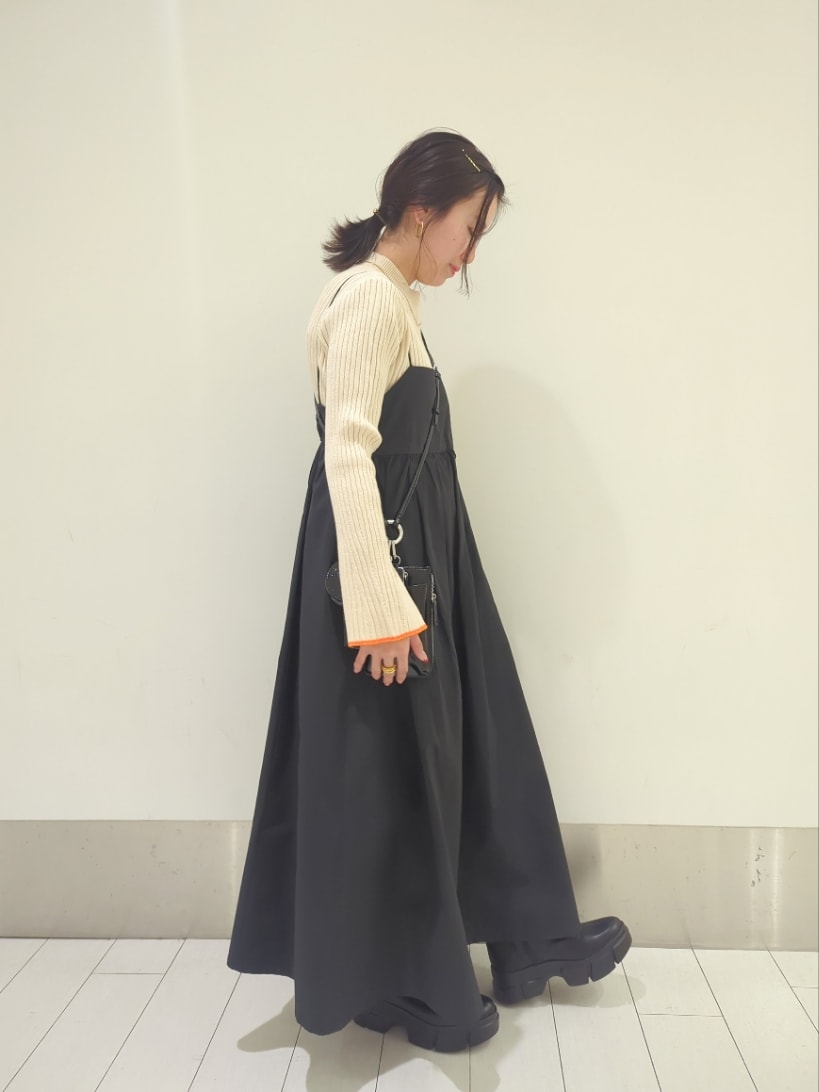 ホワイト系のニット/セーター、ブラック系のワンピース/ドレス、ブラック系のブーツを着用したレディースの冬コーディネートの2枚目の写真