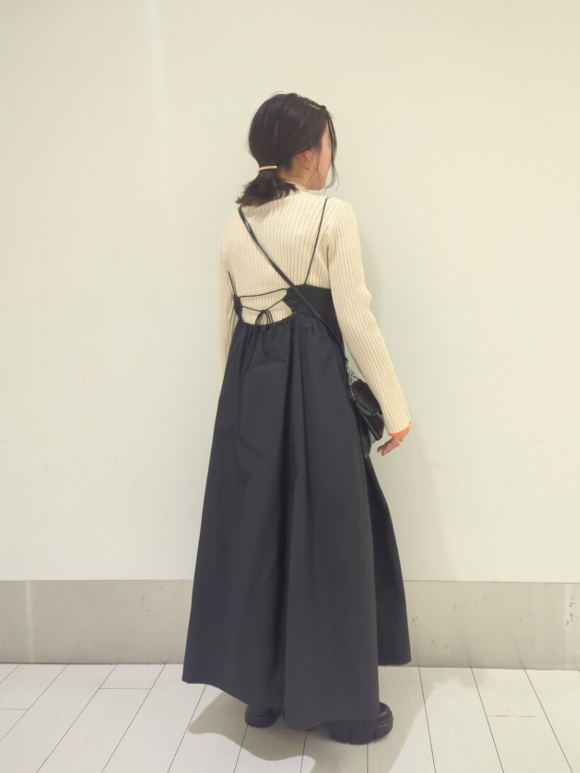 ホワイト系のニット/セーター、ブラック系のワンピース/ドレス、ブラック系のブーツを着用したレディースの冬コーディネートの3枚目の写真