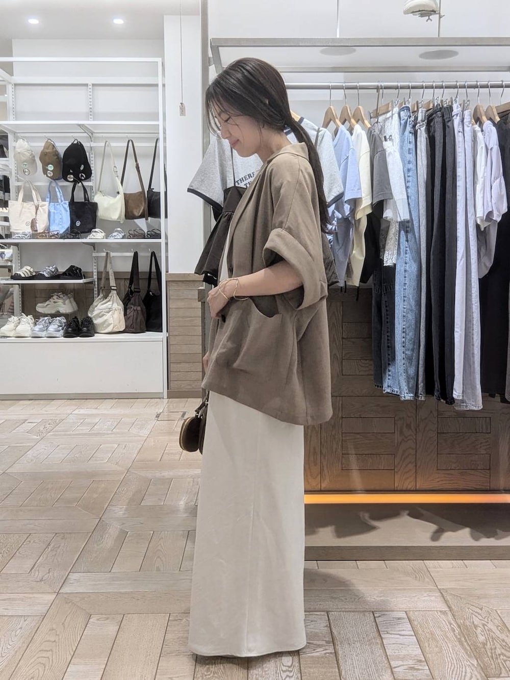 ホワイト系のサンダル、ホワイト系のスカート、ホワイト系のTシャツ/カットソーを着用したレディースの春コーディネートの2枚目の写真