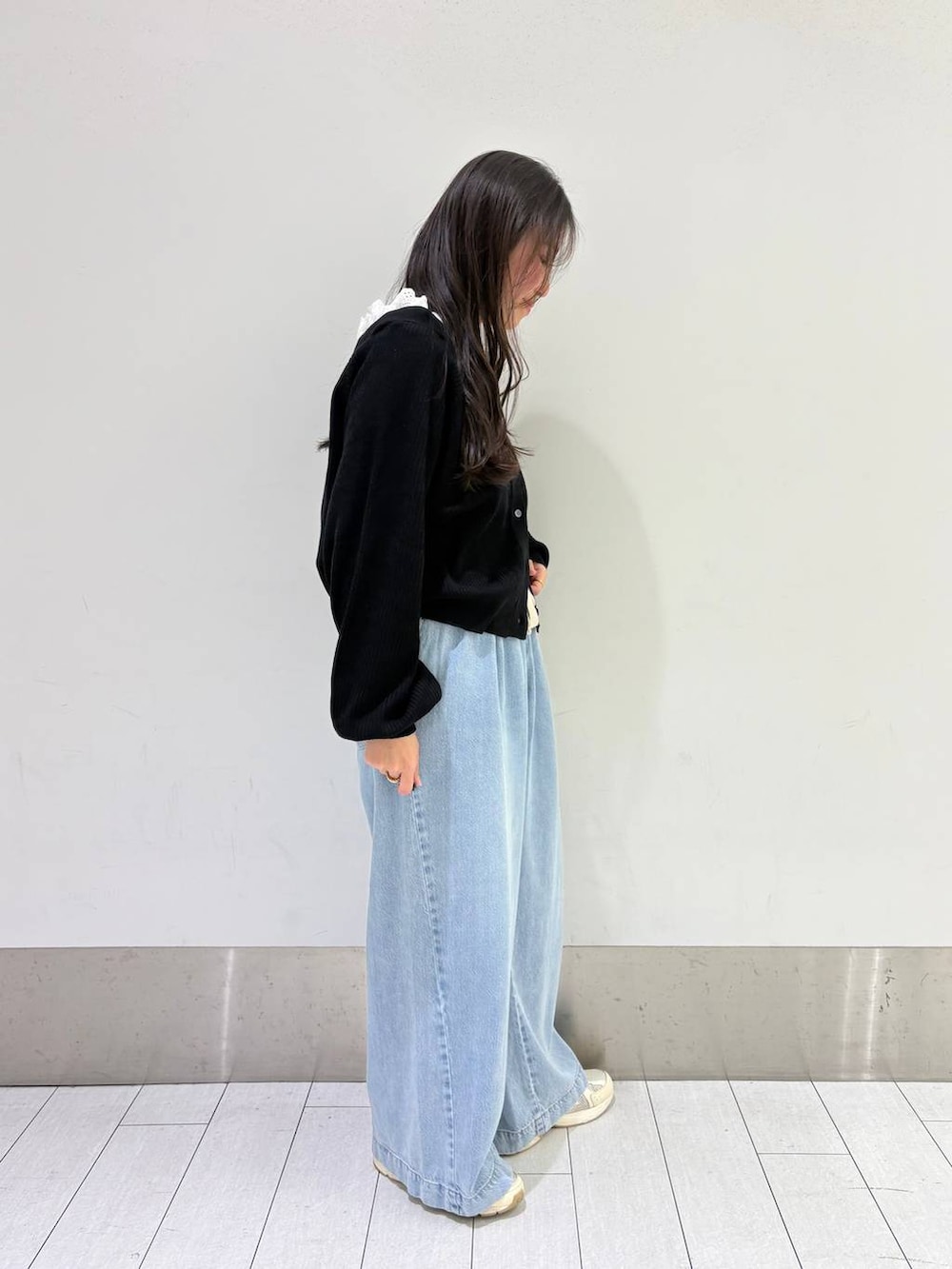 ブルー系のデニムパンツ、ブラック系のカーディガン/ボレロを着用したレディースの冬コーディネートの2枚目の写真