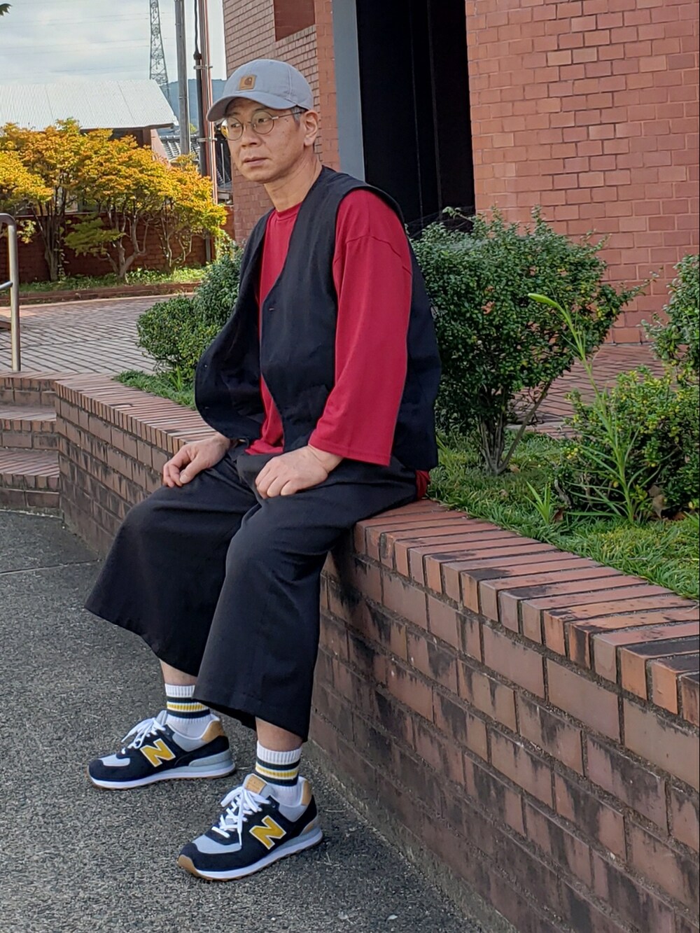 ブルー系のスニーカー、ブラック系のその他パンツ、レッド系のTシャツ/カットソーを着用したメンズの秋コーディネートの2枚目の写真