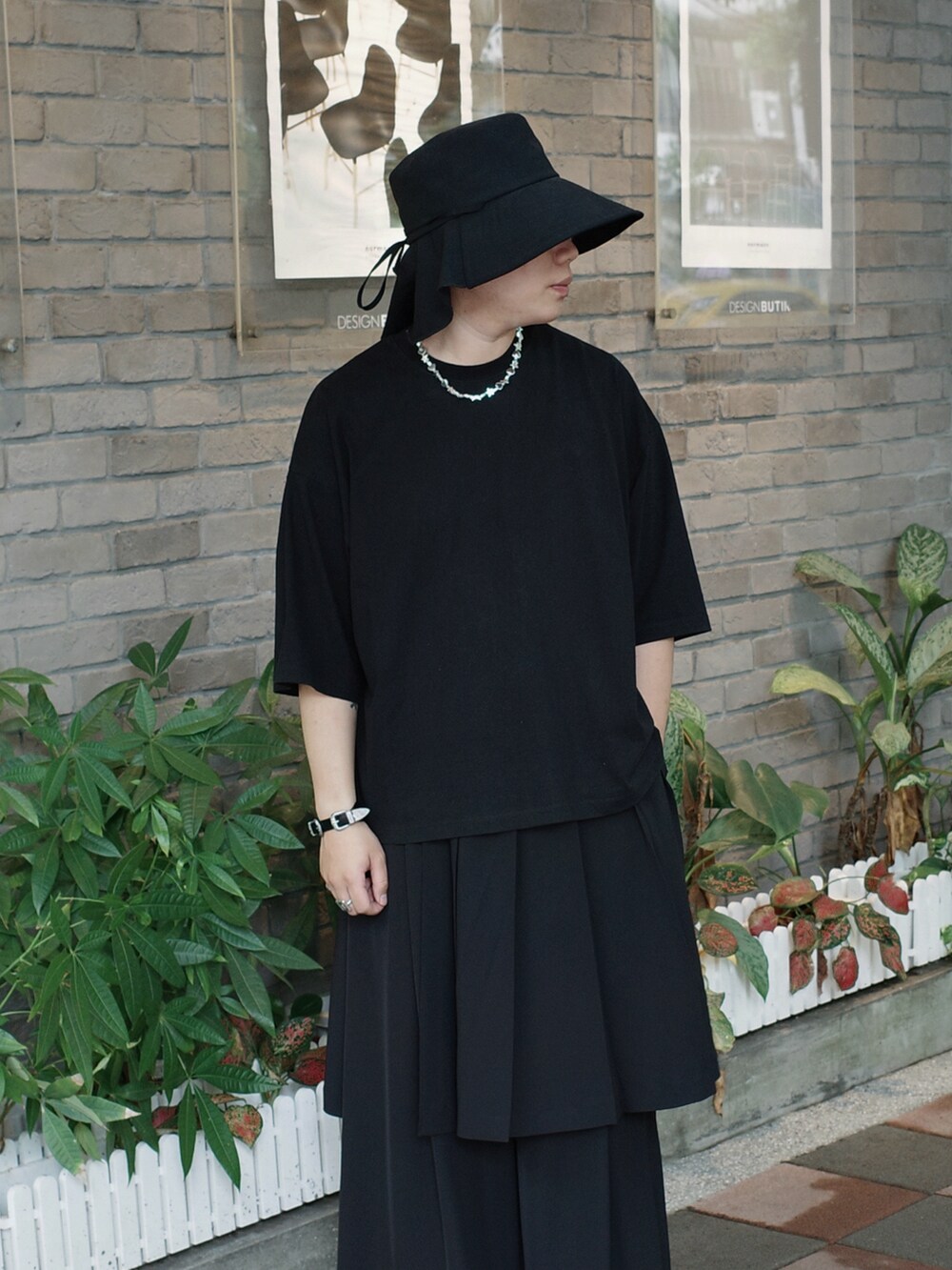 ブラック系のTシャツ/カットソー、ブラック系のスラックス、ブラック系のシューズを着用したメンズの夏コーディネートの2枚目の写真