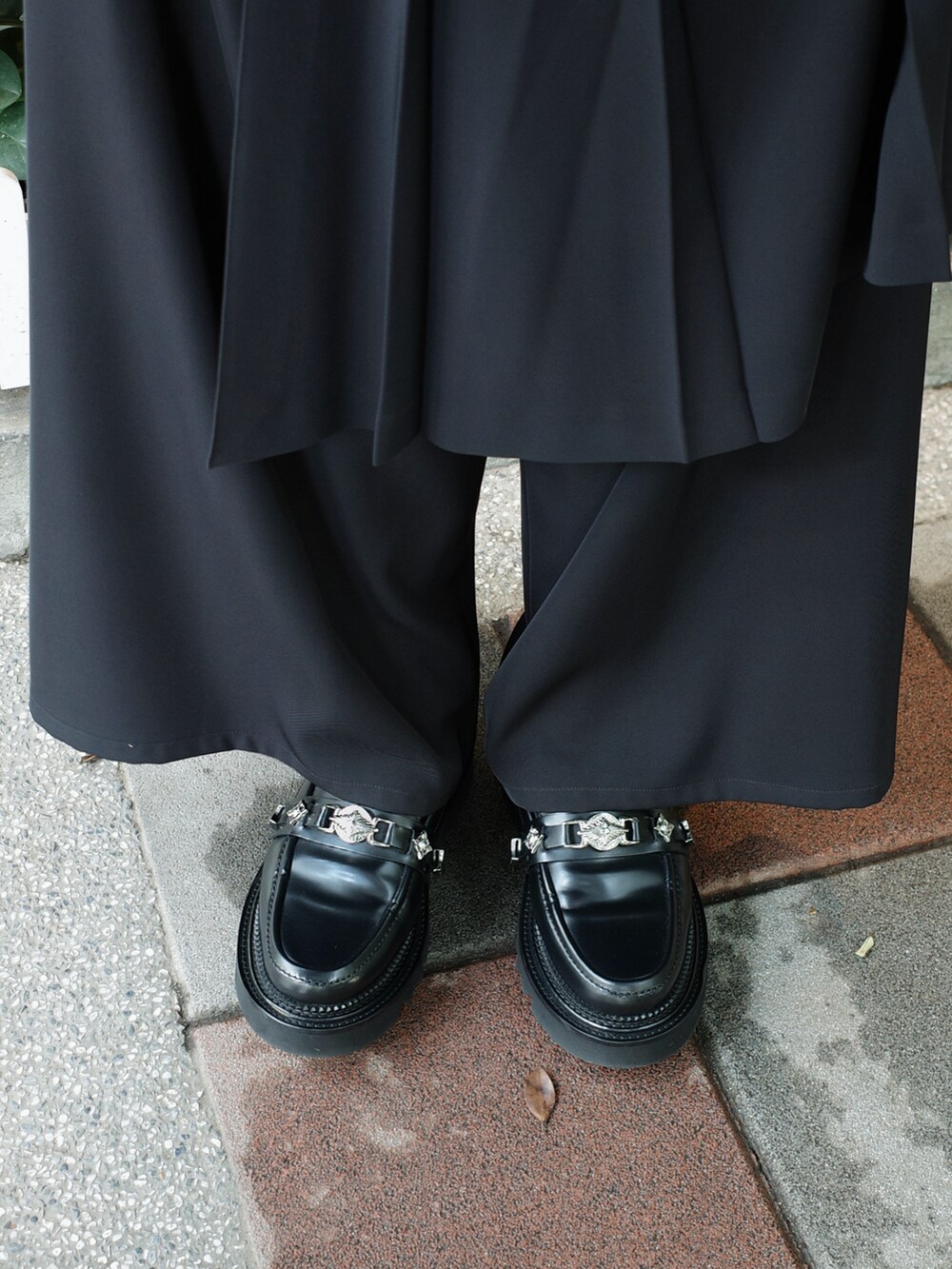 ブラック系のTシャツ/カットソー、ブラック系のスラックス、ブラック系のシューズを着用したメンズの夏コーディネートの3枚目の写真