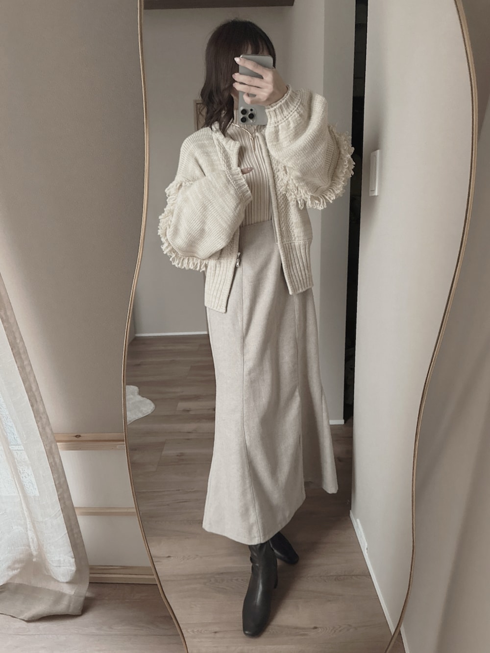 グレー系のショルダーバッグ、ベージュ系のワンピース、ベージュ系のニット/セーターを着用したレディースの春コーディネートの2枚目の写真