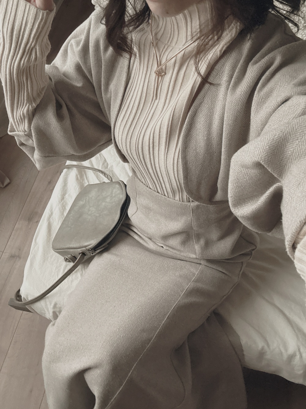 グレー系のショルダーバッグ、ベージュ系のワンピース、ベージュ系のニット/セーターを着用したレディースの春コーディネートの3枚目の写真