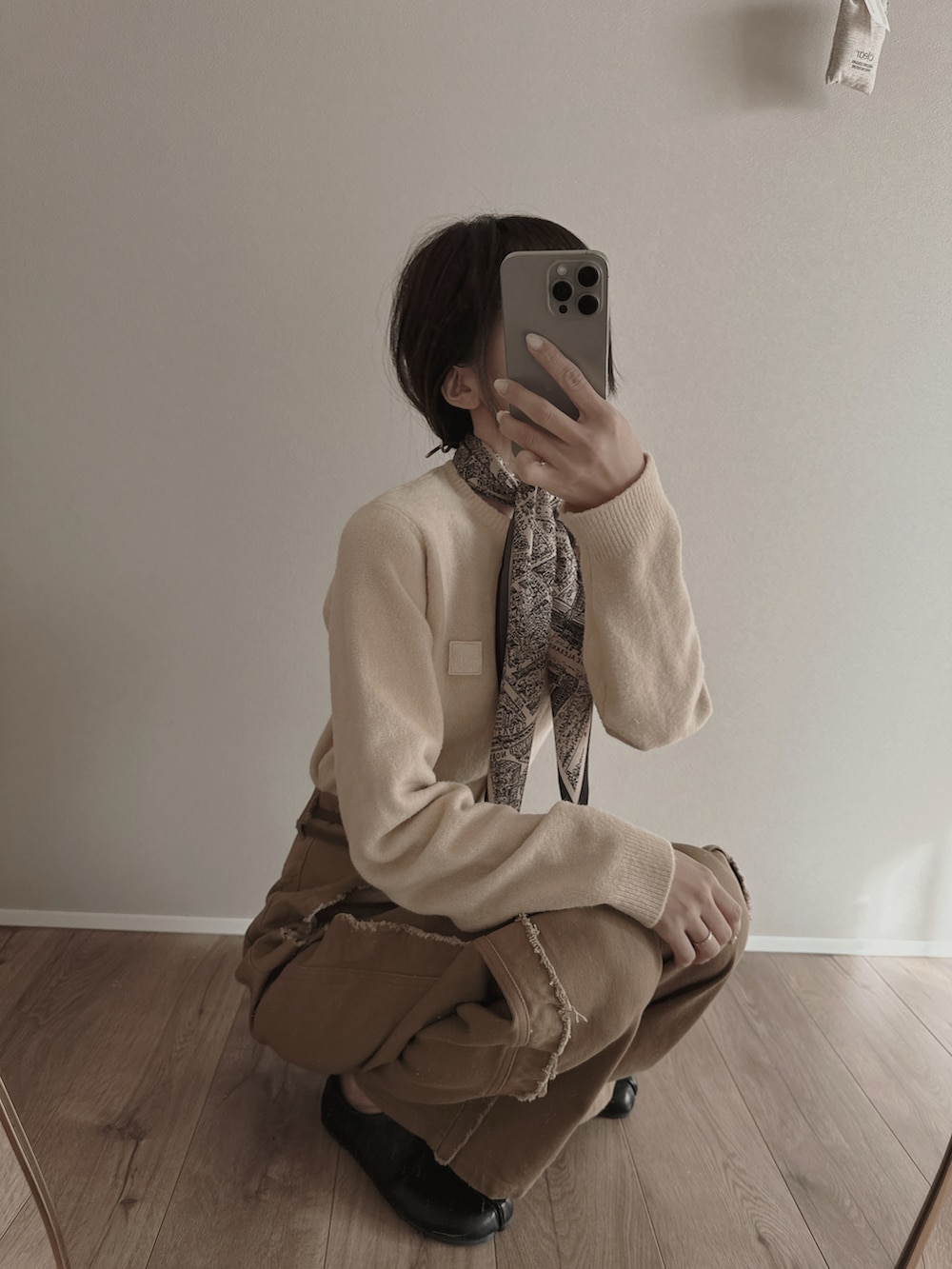 ブラウン系のデニムパンツ、ベージュ系のカーディガン/ボレロを着用したレディースの春コーディネートの2枚目の写真