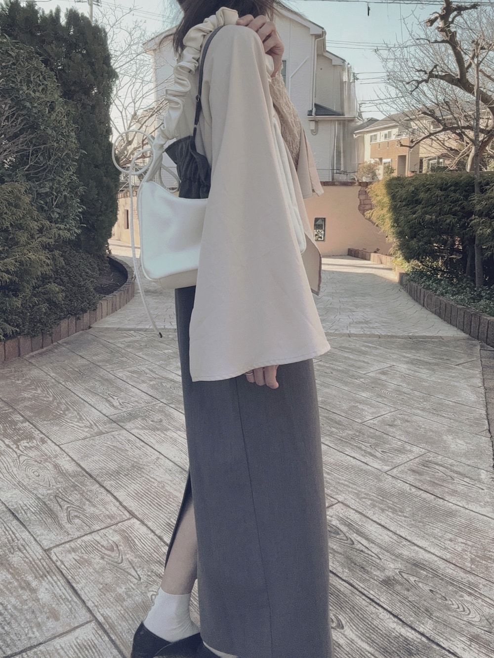 ベージュ系のテーラードジャケット、ホワイト系のショルダーバッグ、グレー系のワンピース/ドレスを着用したレディースの冬コーディネートの2枚目の写真