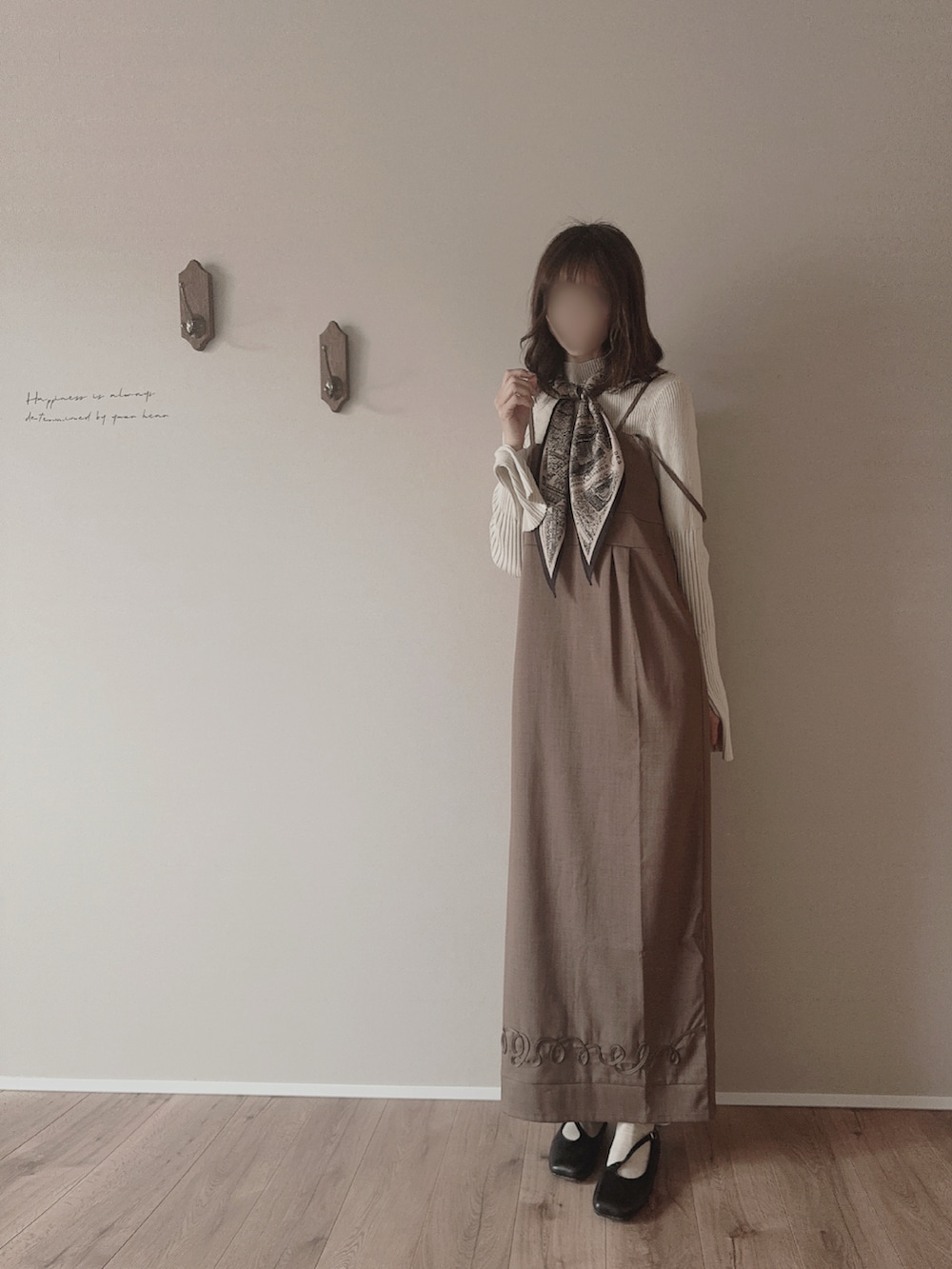 ブラウン系のワンピース/ドレス、ベージュ系のニット/セーター、ブラック系のパンプスを着用したレディースの春コーディネートの2枚目の写真