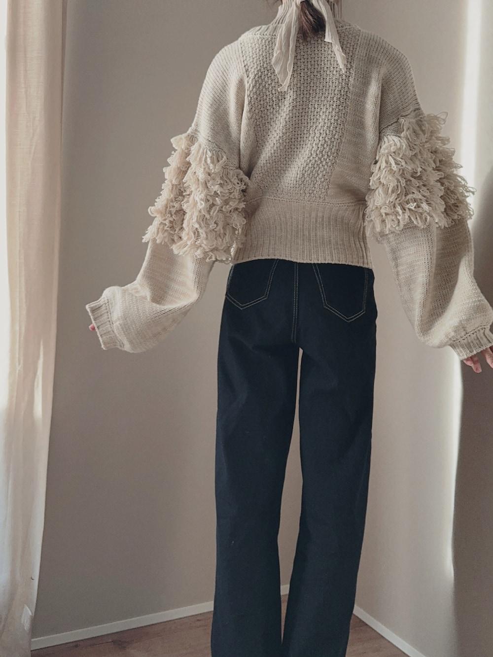 ブルー系のデニムパンツ、ベージュ系のニット/セーター、ベージュ系のニット/セーターを着用したレディースの冬コーディネートの4枚目の写真