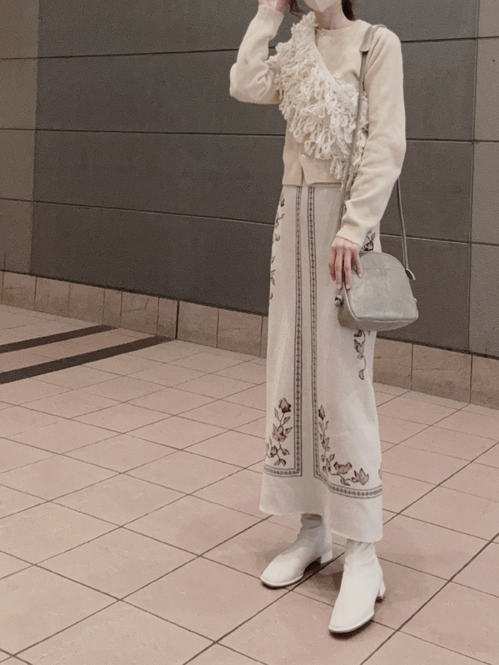 ベージュ系のニット/セーター、ベージュ系のスカート、ベージュ系のネックウォーマー/スヌードを着用したレディースの冬コーディネートの2枚目の写真