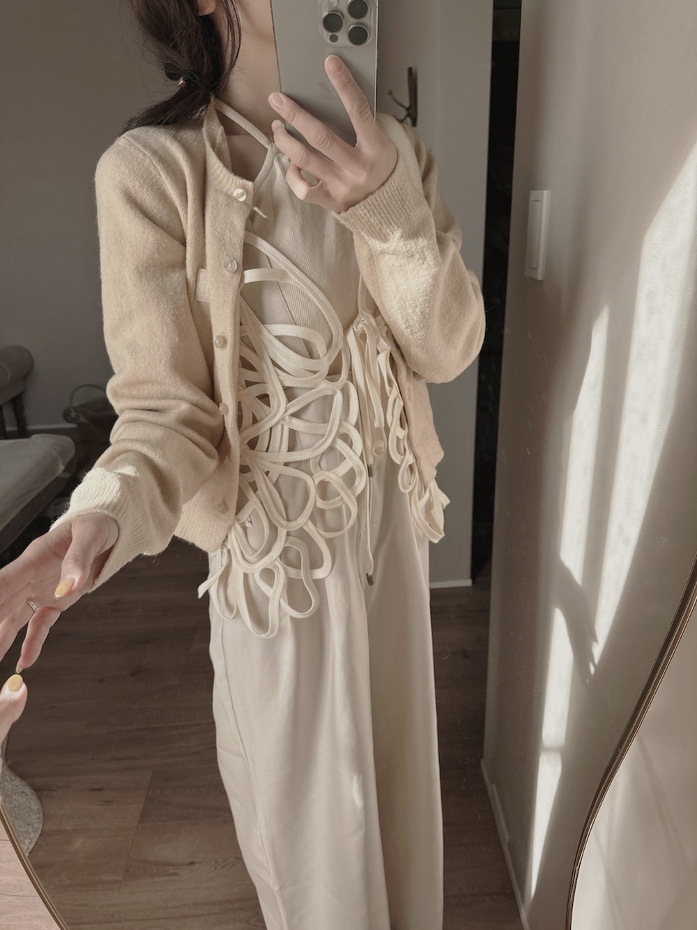 ホワイト系のその他トップス、ベージュ系のカーディガン/ボレロ、ベージュ系のキャミソールを着用したレディースの冬コーディネートの4枚目の写真