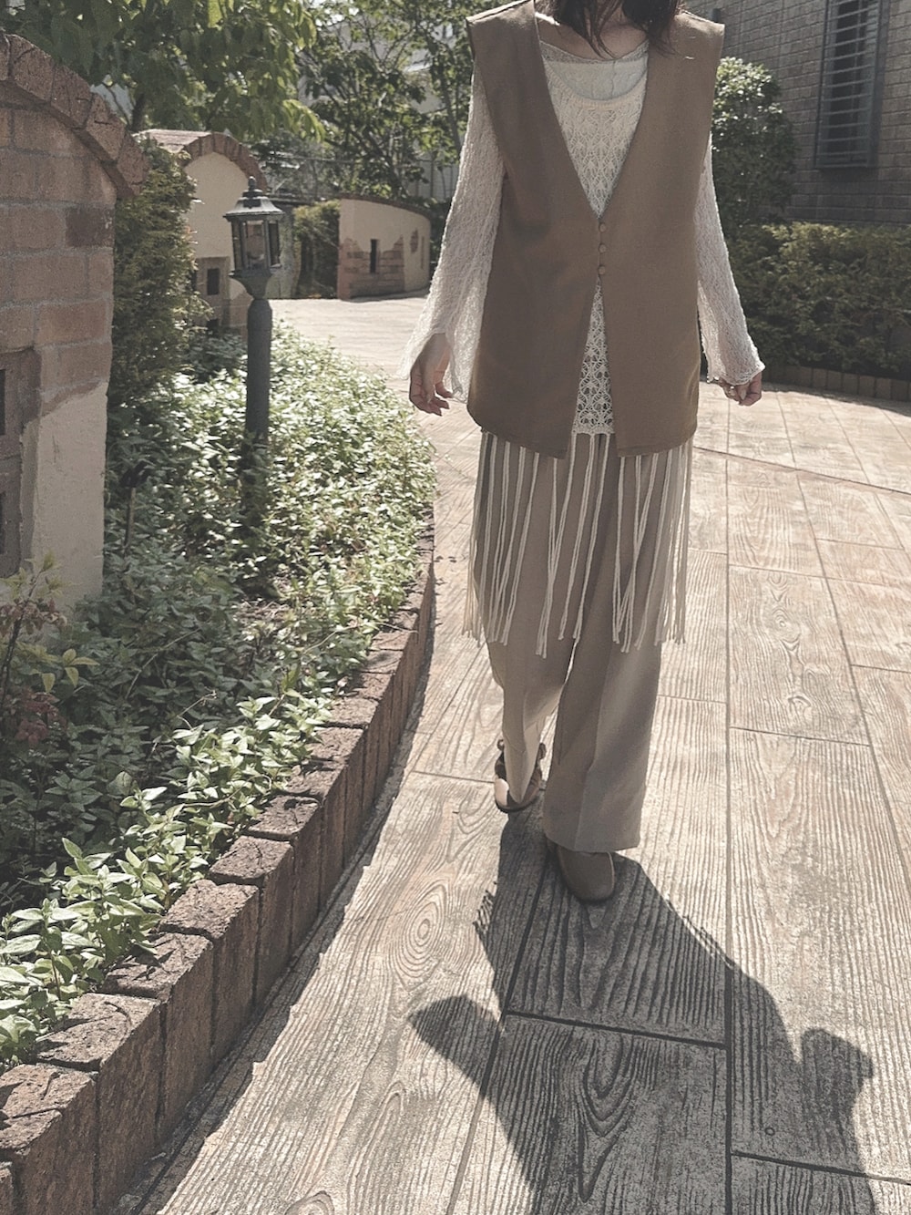 ベージュ系のパンツ、ベージュ系のパンプス、ベージュ系のキャミソールを着用したレディースの春コーディネートの3枚目の写真