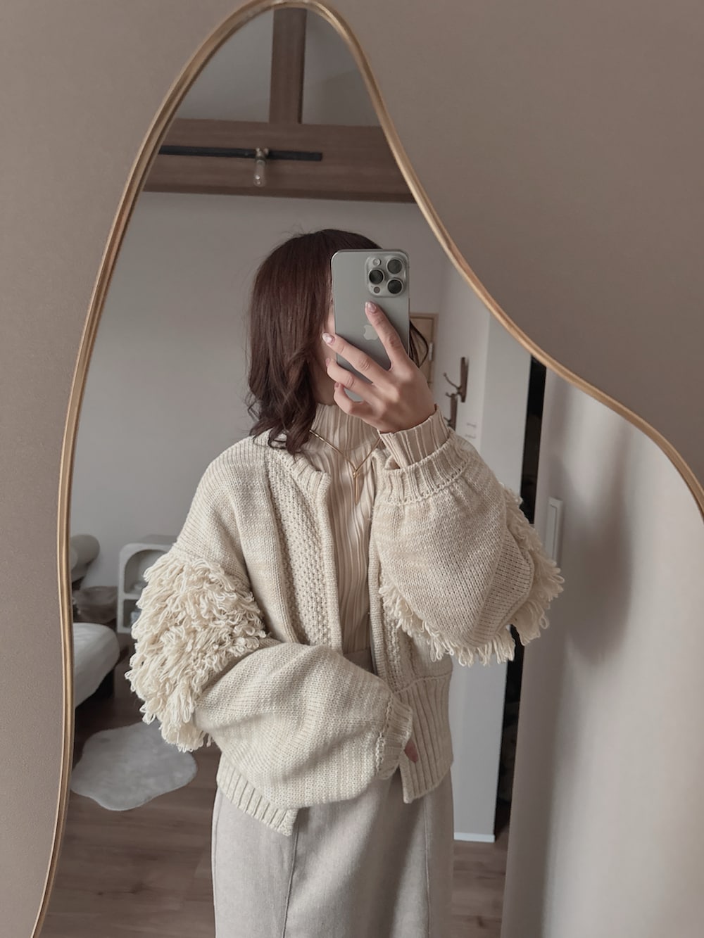 グレー系のショルダーバッグ、ベージュ系のワンピース、ベージュ系のニット/セーターを着用したレディースの春コーディネートの4枚目の写真