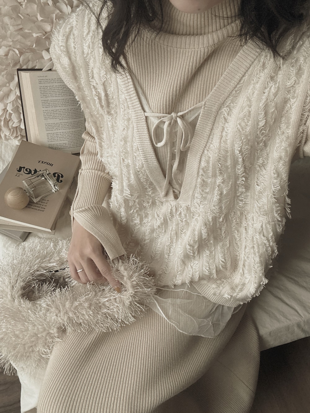 ホワイト系のパンプス、ホワイト系のベスト、ホワイト系のワンピースを着用したレディースの冬コーディネートの3枚目の写真