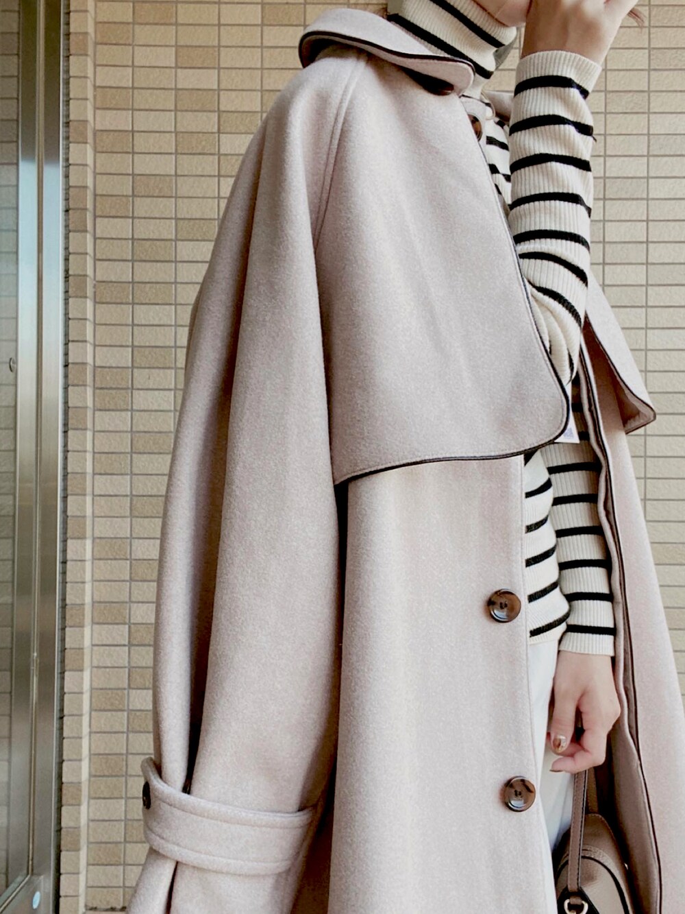 ベージュ系のジャケット/アウター、ホワイト系のニット/セーター、ホワイト系のパンツを着用したレディースの秋コーディネートの2枚目の写真