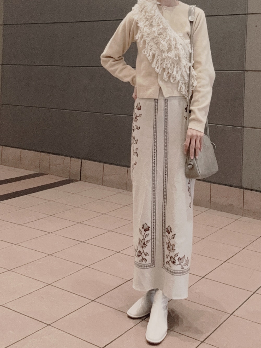 ベージュ系のニット/セーター、ベージュ系のスカート、ベージュ系のネックウォーマー/スヌードを着用したレディースの冬コーディネートの4枚目の写真