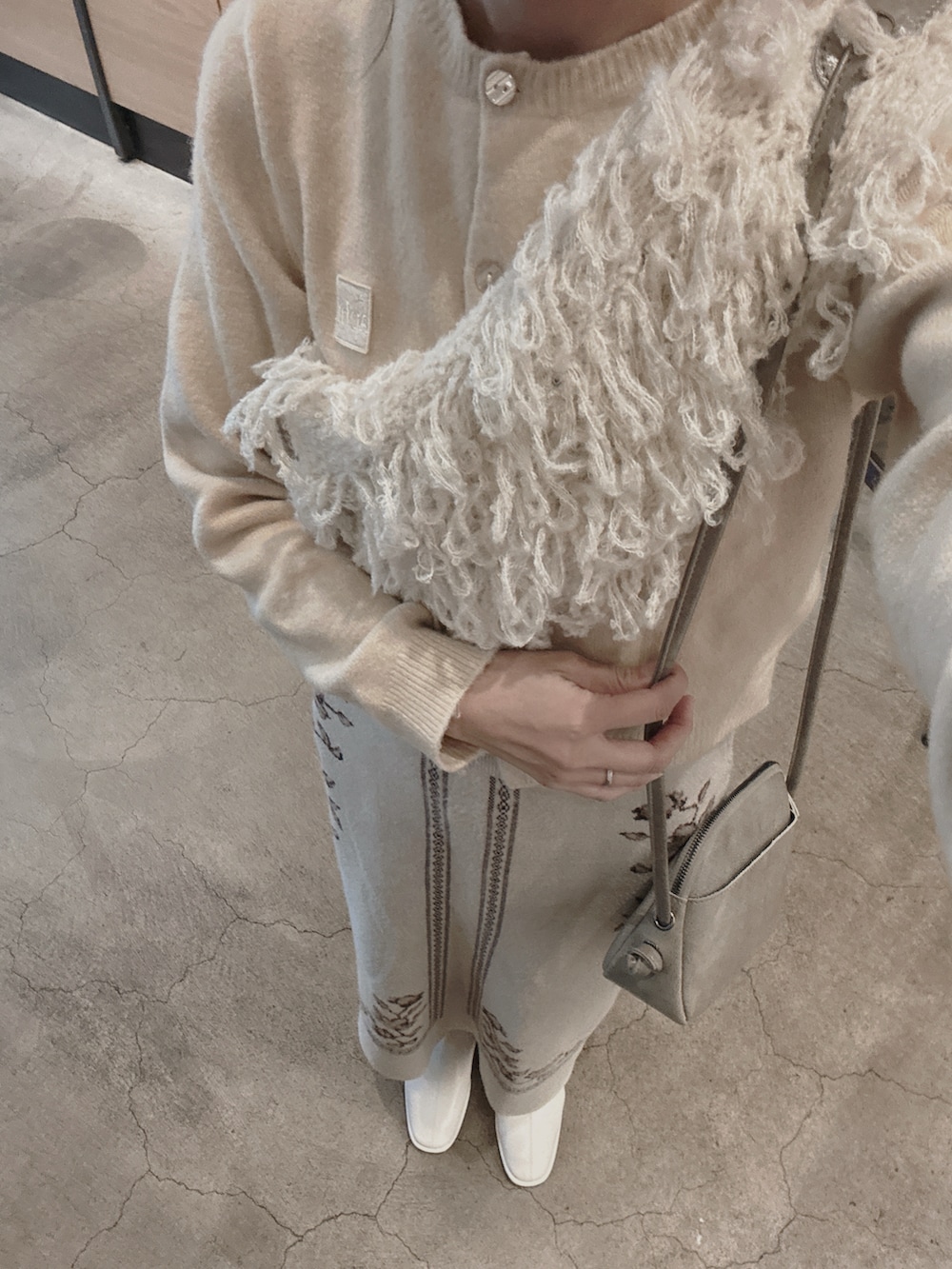 ベージュ系のニット/セーター、ベージュ系のスカート、ベージュ系のネックウォーマー/スヌードを着用したレディースの冬コーディネートの3枚目の写真